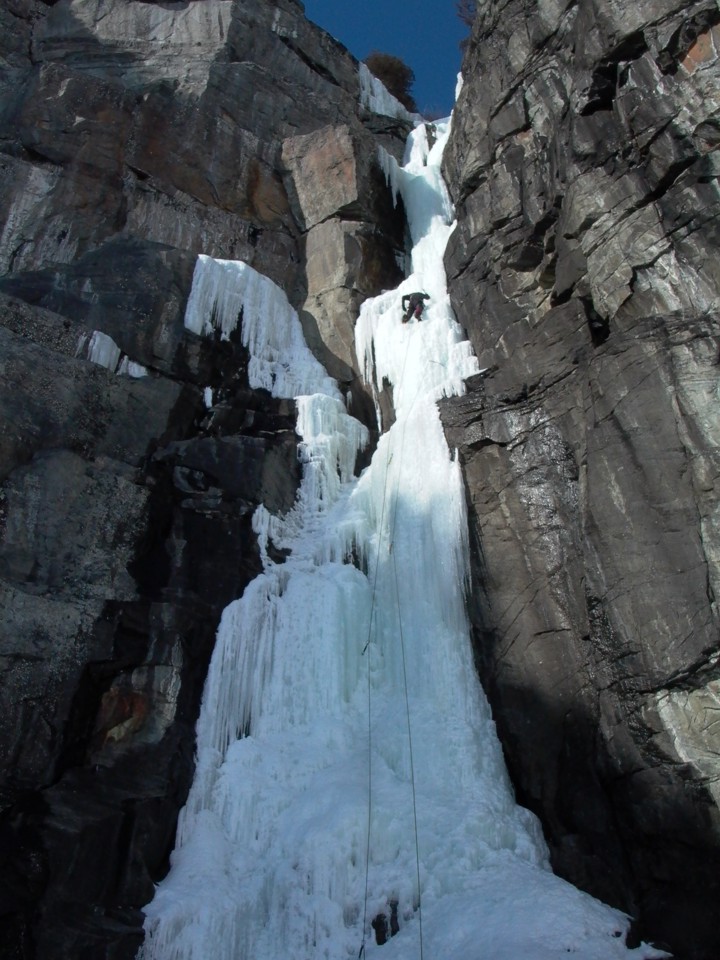 The second crux climbs the ice above the climber through the constriction in the rock