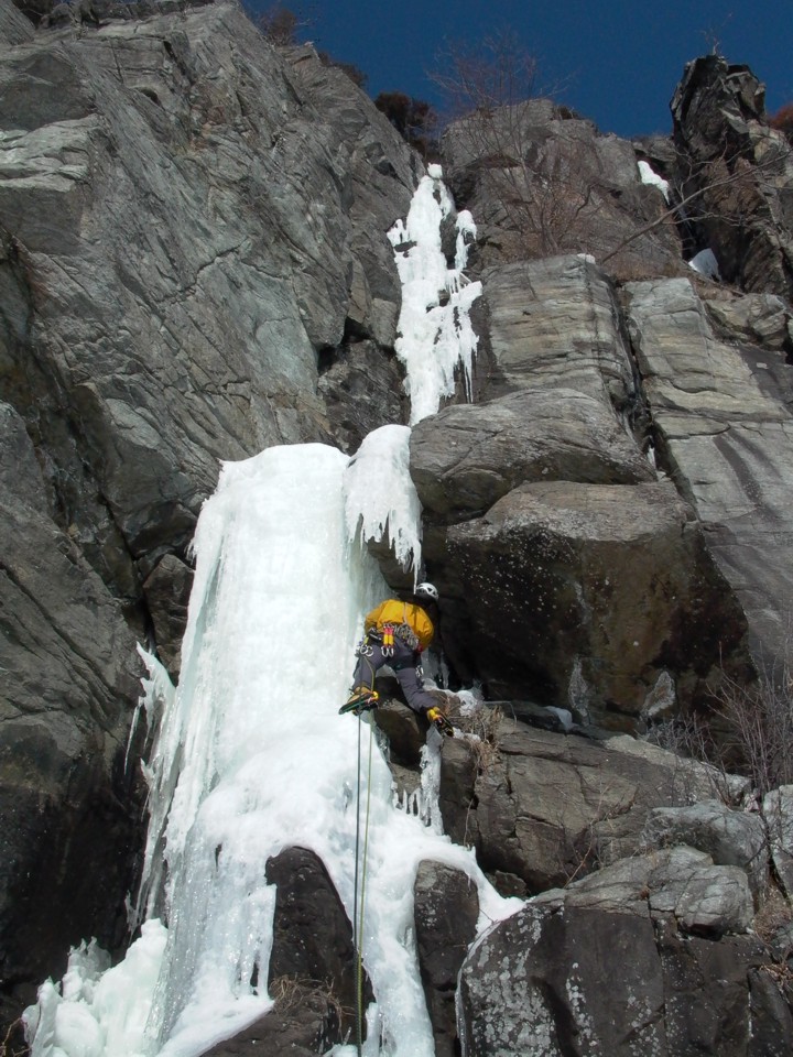 Jeremy climbs the initial ice bulge, using nuts on the right for protection