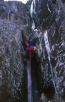 Tom climbing around the chockstone on the direct start of Left of Passage