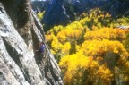 Bev lowers from the anchors with colorful fall foliage in the background