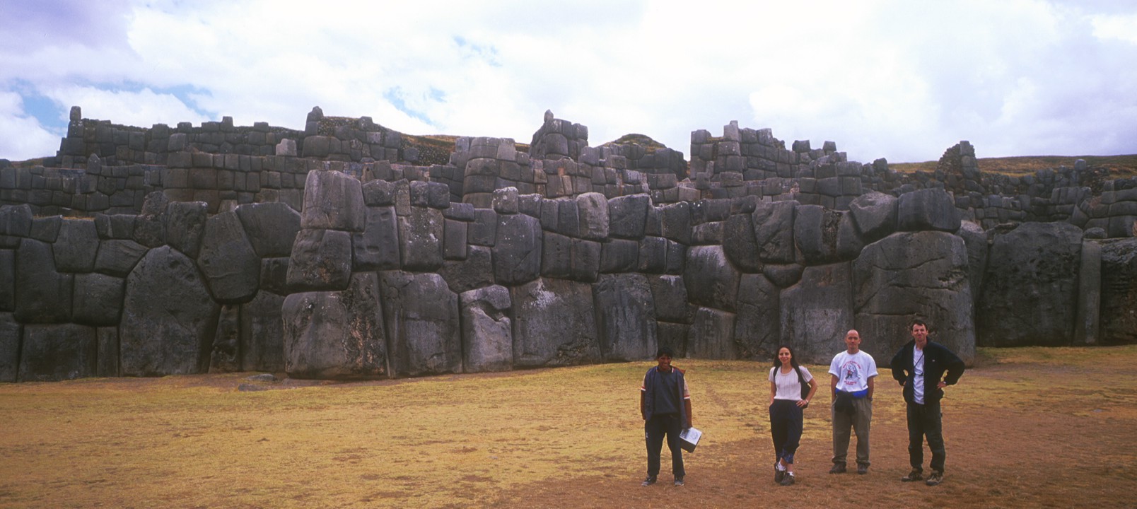 The group poses in front of an Inca wall