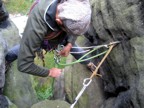 Rappelling the backside of the tower down to the grass; the terrain is comfortably navigated with bare feet because of the sand