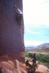 Brian reaches left at the crux, belayed by Mioara