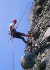 Close-up of Manos rappelling amidst a sea of pebbles