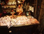 Boy and mother cleaning chickens in the market