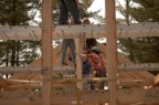 Jim holds the temporary brace as the others lower the ridge pole into position