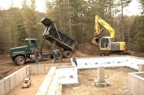 Excavation crew dumping sand, then moving it into the foundation