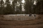 Foundation as seen from the front of the hut as the excavation crew pack sand into the interior