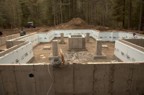 View of the foundation from the west. The large concrete box in the center is the foundation for the chimney; the smaller free-standing piers are for posts in the timber frame.