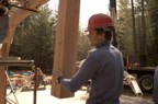 Jim positions a post onto a metal plate on the foundation