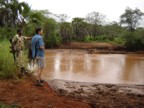 Jim and the Corporal examine the fresh hippo tracks near the camp site